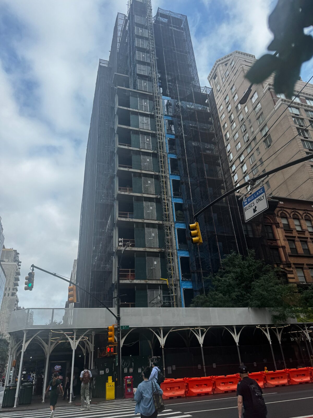 High-rise construction project with scaffolding and a sidewalk shed in New York City